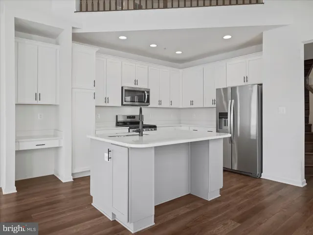 a kitchen with kitchen island white cabinets and stainless steel appliances