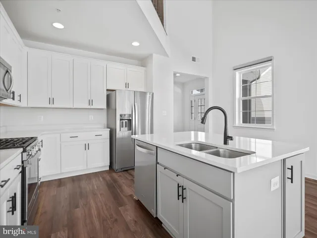 a kitchen with white cabinets appliances and sink