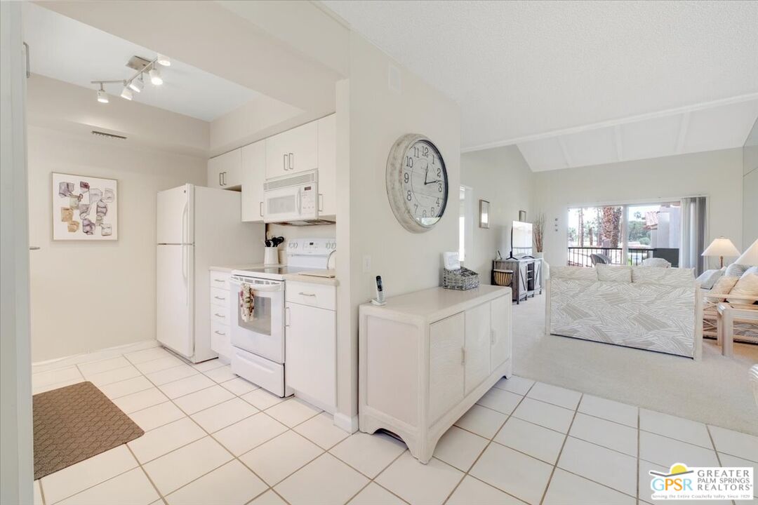 1421 North Sunrise Way, Unit 34 Palm Springs, CA 92262 - Photo 11 of 34 a large white kitchen with cabinets