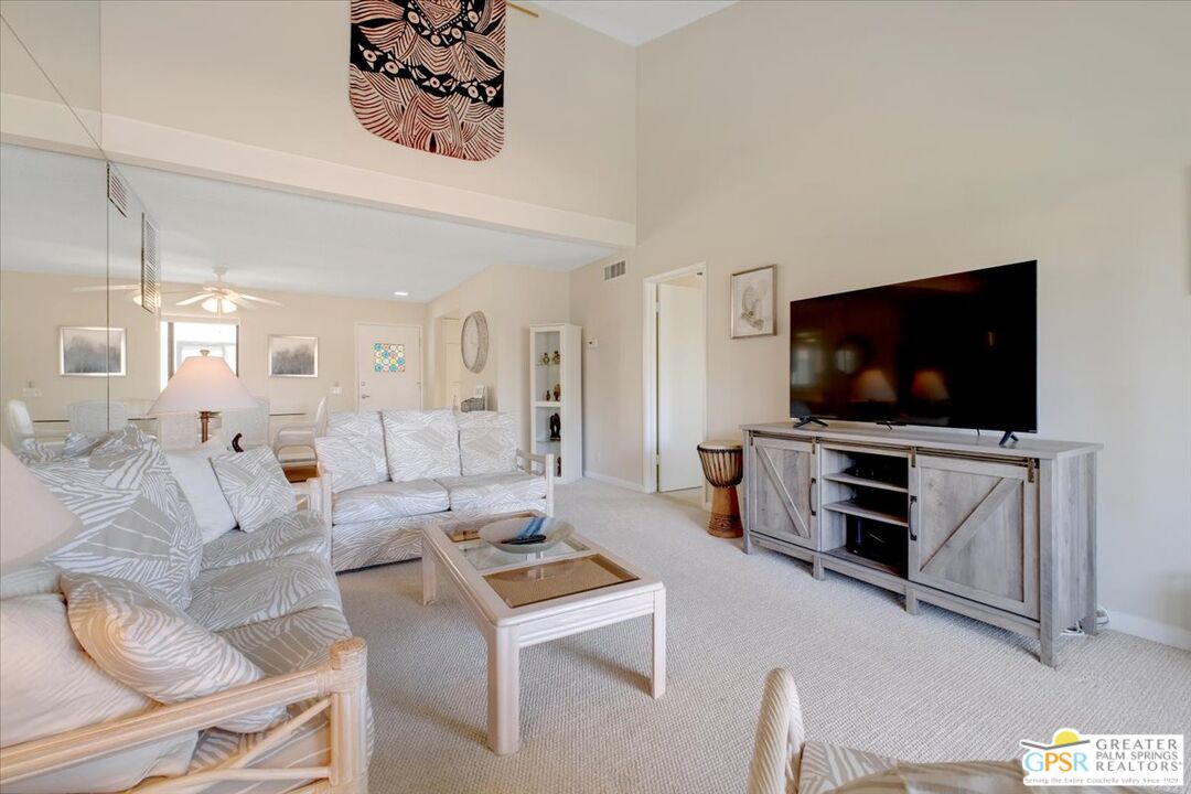 1421 North Sunrise Way, Unit 34 Palm Springs, CA 92262 - Photo 13 of 34 a living room with furniture and a flat screen tv