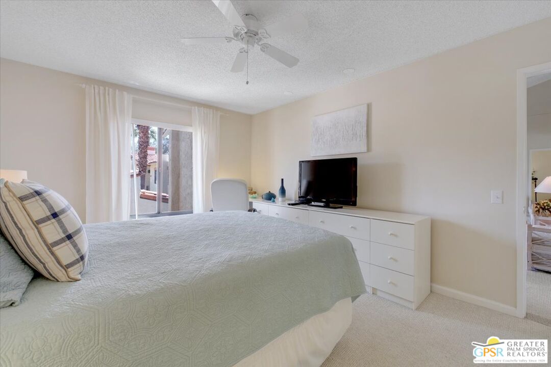 1421 North Sunrise Way, Unit 34 Palm Springs, CA 92262 - Photo 18 of 34 a bedroom with a bed and a television