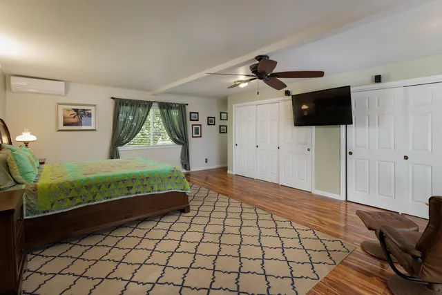 a bedroom with a bed and a flat tv screen on the dresser