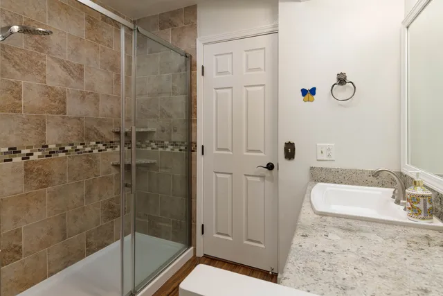 a bathroom with a granite countertop bathtub shower and vanity