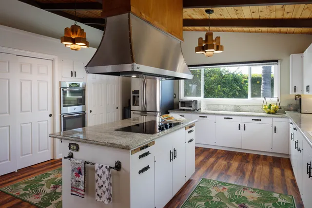 a kitchen with stainless steel appliances granite countertop a sink stove and cabinets