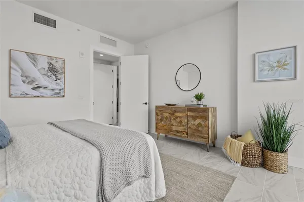 a bedroom with a bed a couch and potted plant