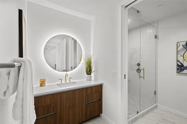 a bathroom with a double vanity sink mirror and shower