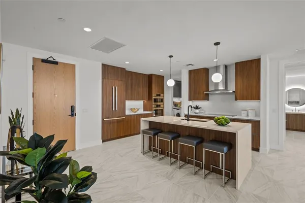 a kitchen with kitchen island a counter top space a sink stainless steel appliances and cabinets