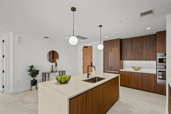 a kitchen with stainless steel appliances granite countertop a sink a oven and a counter space