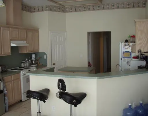 a kitchen with stainless steel appliances a sink a stove and a refrigerator with wooden floor