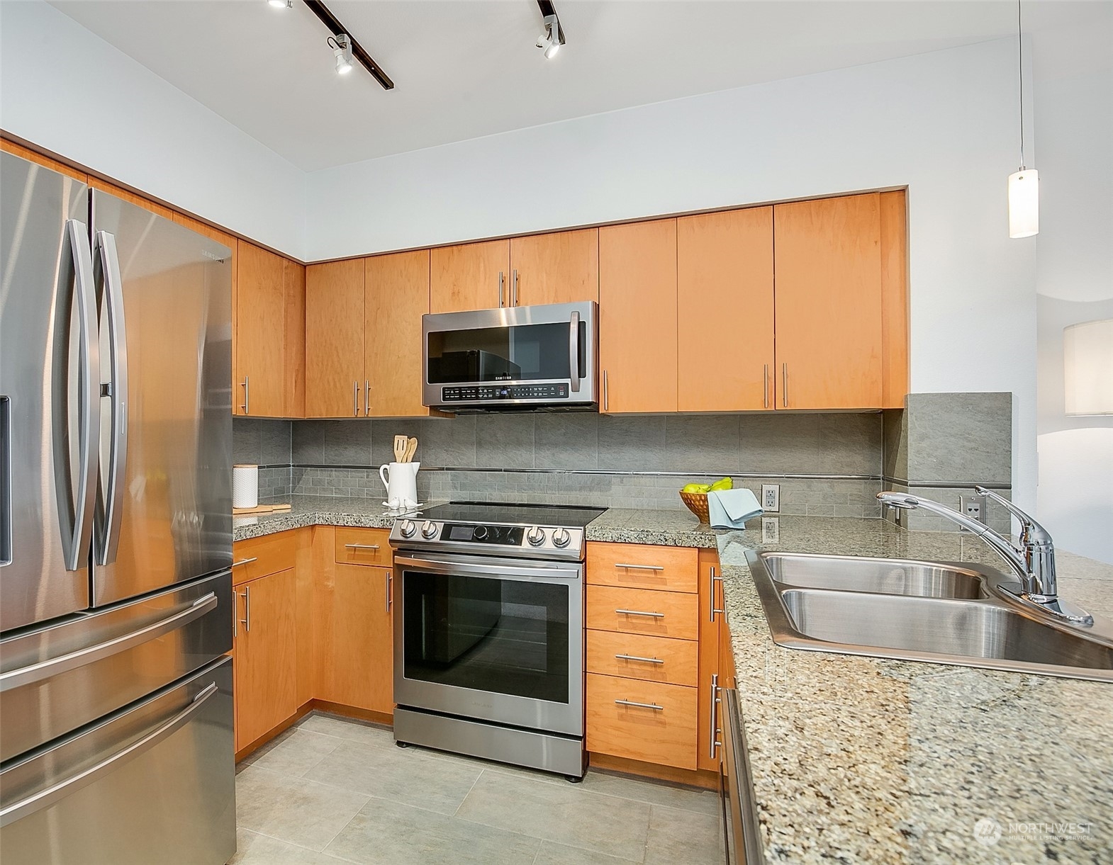 5440 Leary Avenue Northwest, Unit 417 Seattle, WA 98107 - Photo 10 of 21 a kitchen with stainless steel appliances granite countertop a sink stove and refrigerator