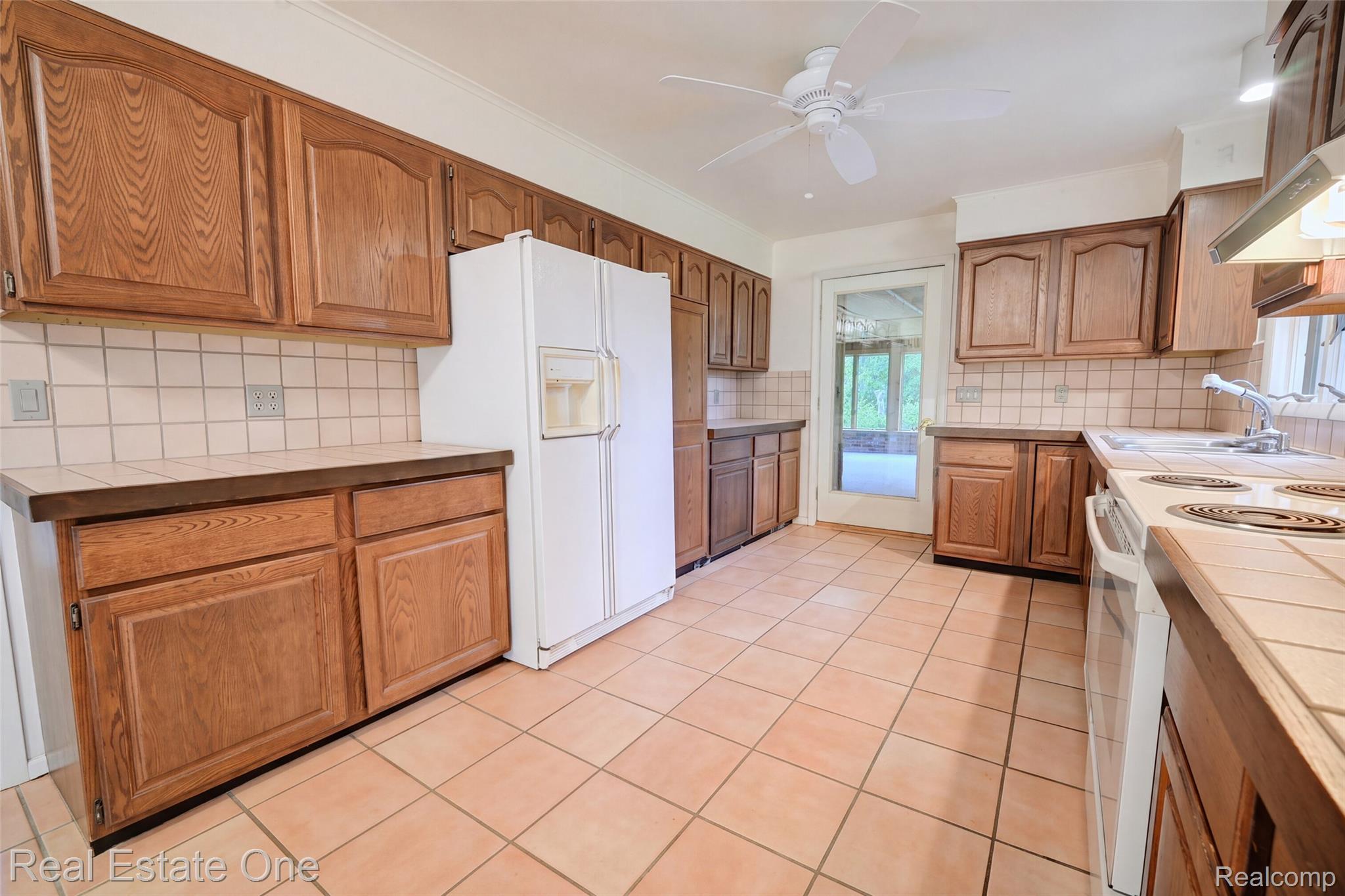 895 Rowe Road Milford, MI 48380 - Photo 5 of 50 Kitchen featuring extensive wood cabinetry, tile flooring, tile countertops, and a ceiling fan
