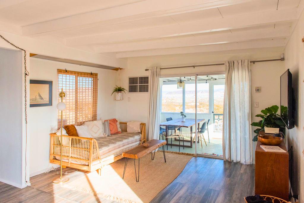 1195 Canyon Road Twentynine Palms, CA 92277 - Photo 19 of 25 a living room with furniture floor to ceiling window and wooden floor