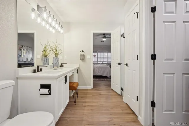 a bathroom with a sink a toilet a mirror and shower