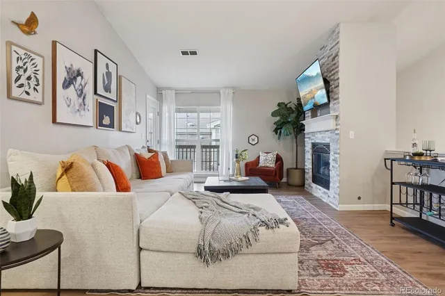 a bedroom with a bed a couch and potted plant on the dresser