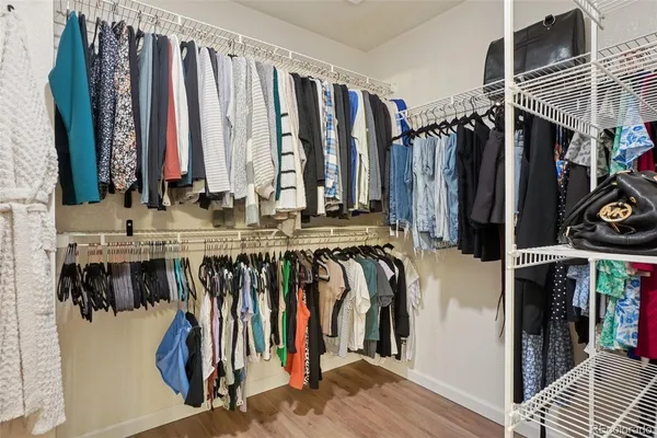 a view of walk in closet with clothes and shoes