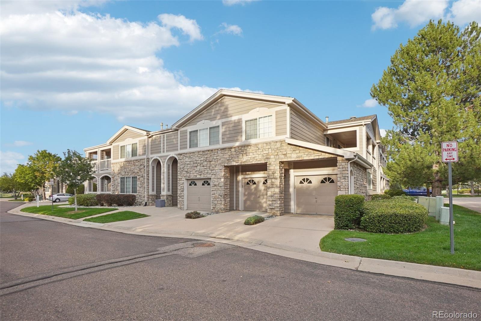 4271 South Blackhawk Circle, Unit 2C Aurora, CO 80014 - Photo 42 of 45 a view of a white house with a big yard and large trees