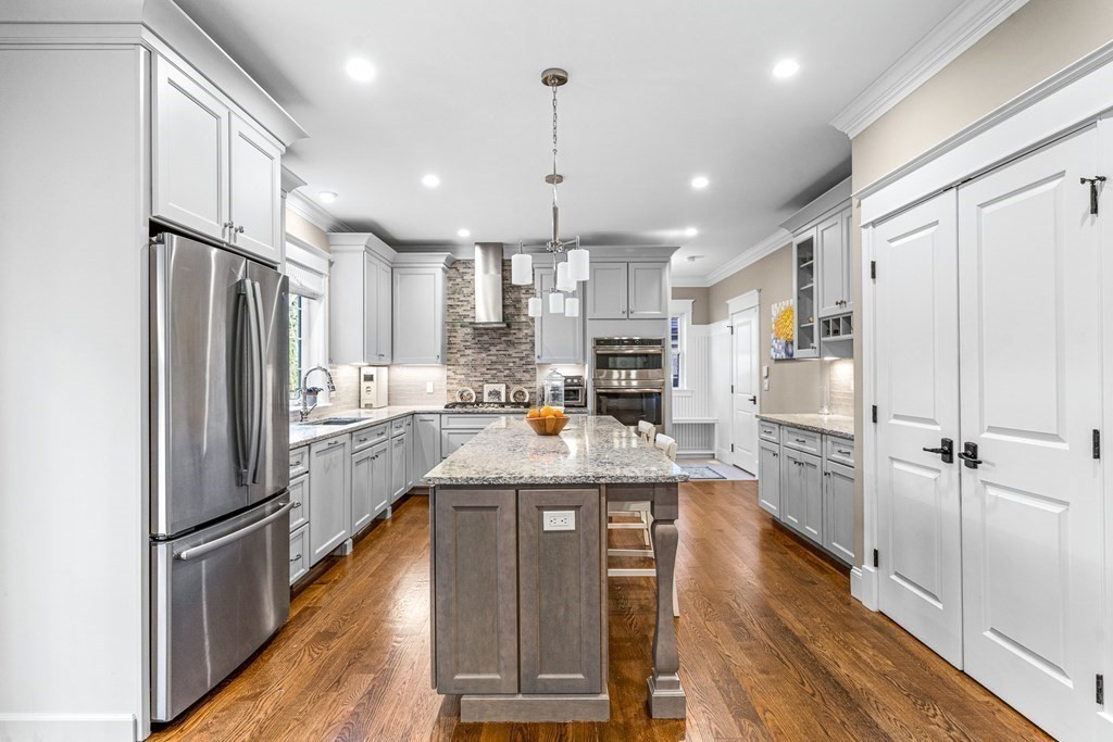 508 South Border Road Winchester, MA 01890 - Photo 13 of 41 a kitchen with stainless steel appliances granite countertop a refrigerator a stove a sink dishwasher and white cabinets with wooden floor