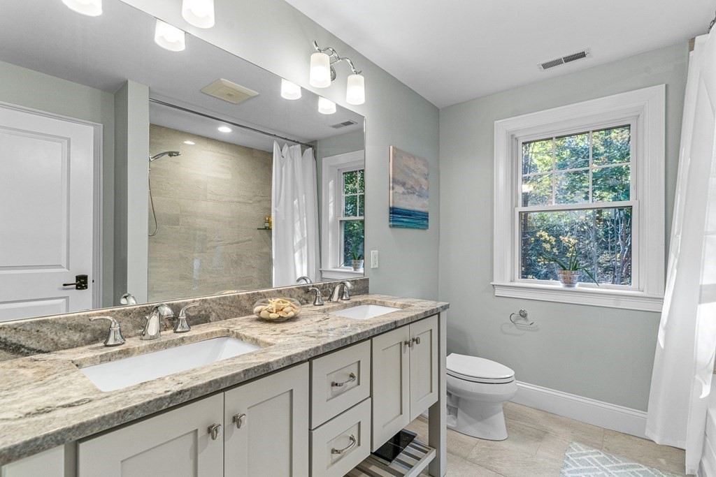 508 South Border Road Winchester, MA 01890 - Photo 26 of 41 a bathroom with a granite countertop sink toilet a large mirror and a window