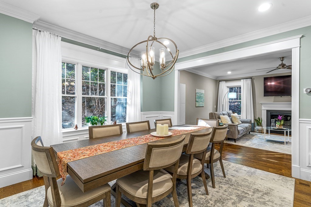 508 South Border Road Winchester, MA 01890 - Photo 7 of 41 a dining room with wooden floor a chandelier a wooden table and chairs