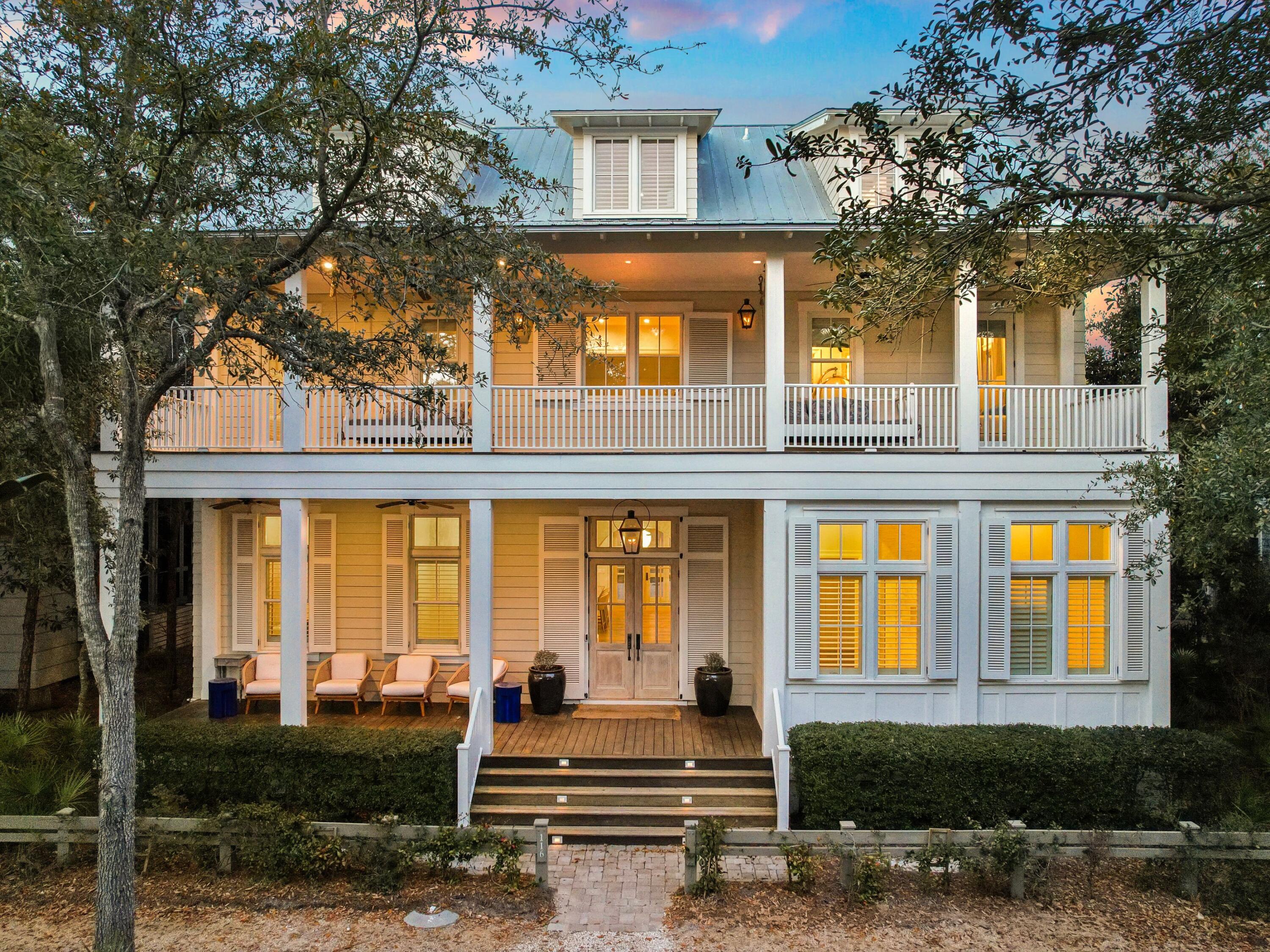 a front view of a house with a yard balcony and outdoor seating