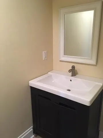 a bathroom with a sink vanity and a mirror