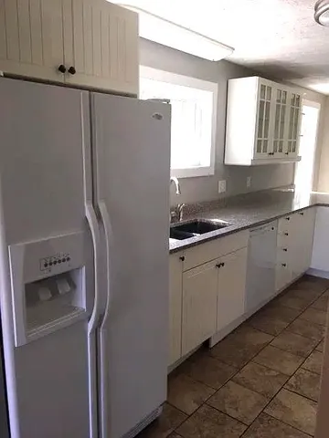 a kitchen with a refrigerator and a sink