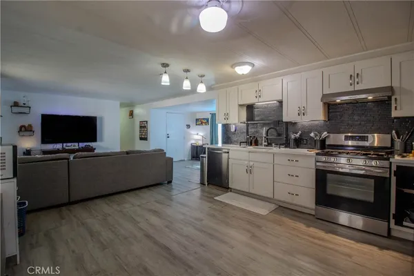 a kitchen with stainless steel appliances white cabinets a sink dishwasher a stove and a refrigerator