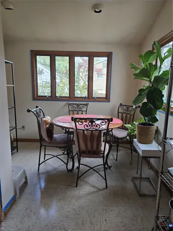 a dining room with furniture and a potted plant