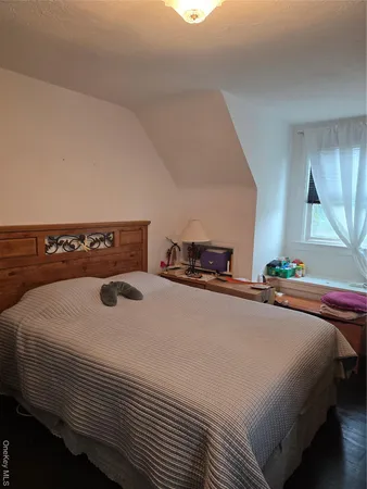 a bedroom with a bed and a large mirror on the dresser