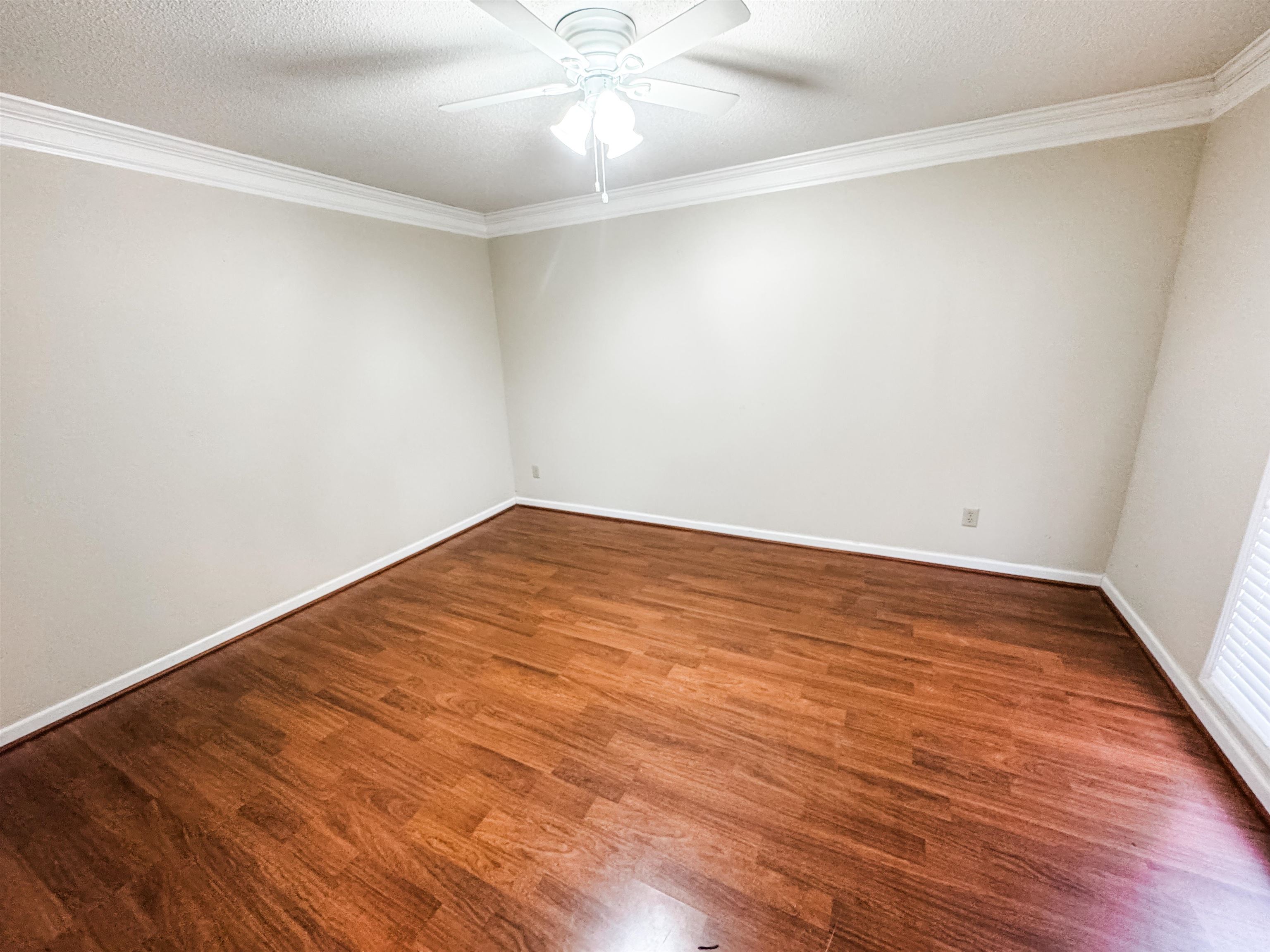 10431 Pilot Rock Road Collierville, TN 38017 - Photo 2 of 15 Empty room featuring ceiling fan, dark wood-type flooring, a textured ceiling, and ornamental molding