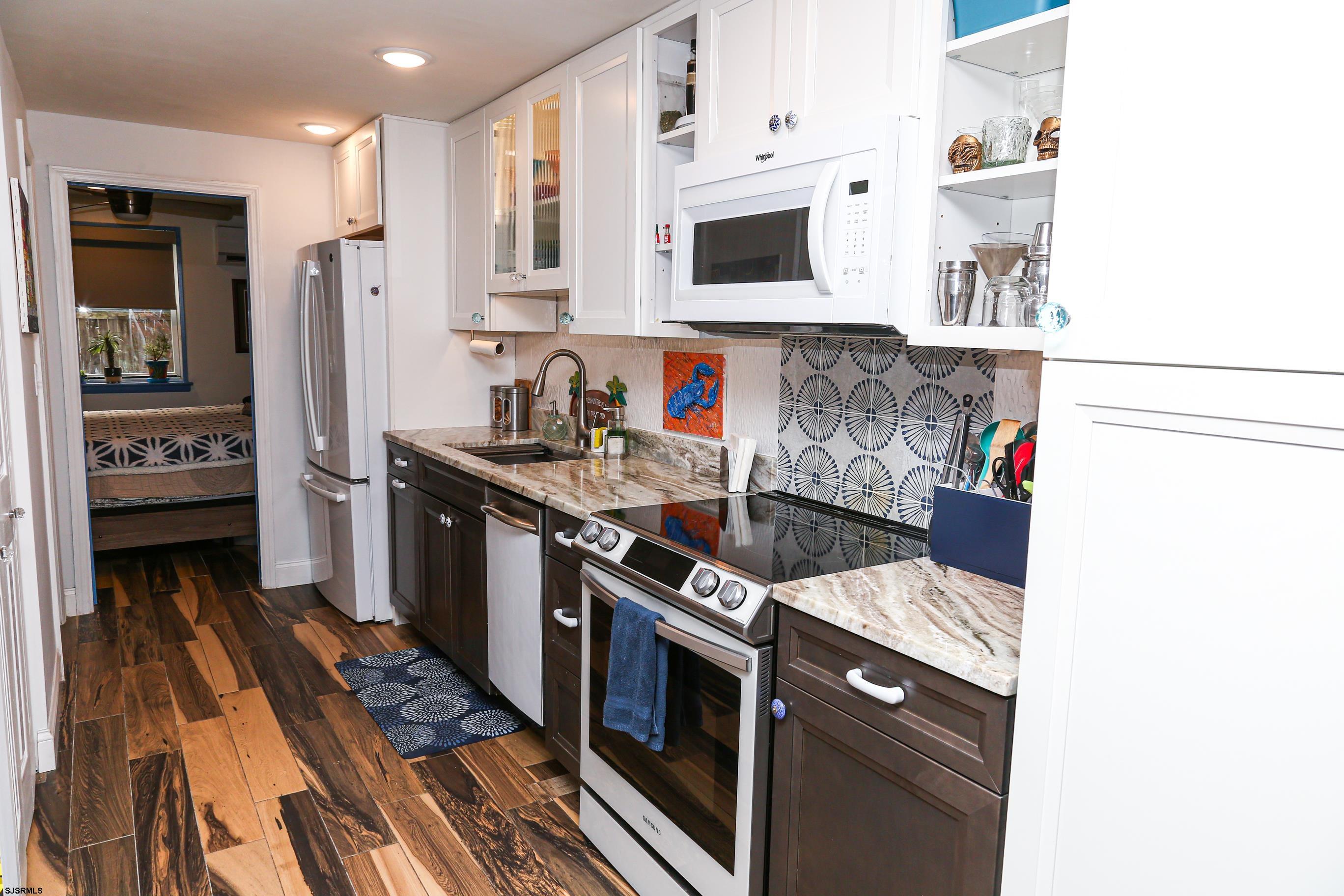 401 37th Street South, Unit 5 Brigantine, NJ 08203 - Photo 9 of 48 a kitchen with stainless steel appliances granite countertop a stove and a refrigerator