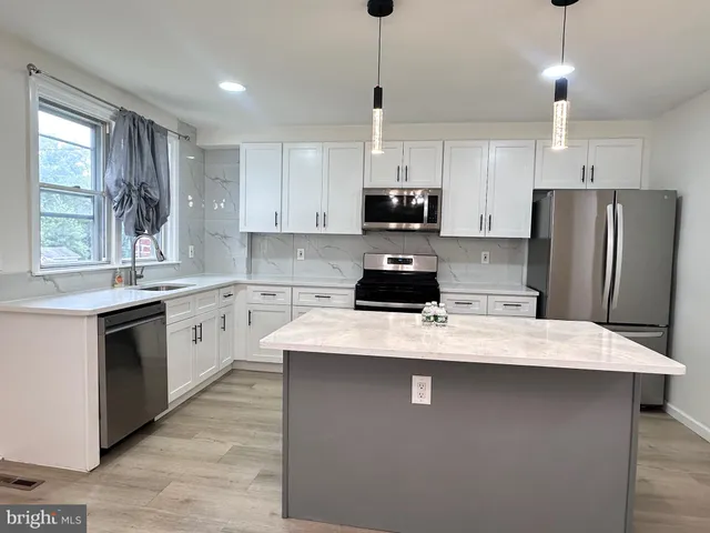 a kitchen with stainless steel appliances a refrigerator sink and wooden cabinets