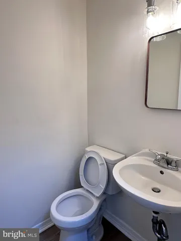 a bathroom with a toilet a sink and mirror