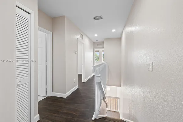 a view of a hallway with wooden floor