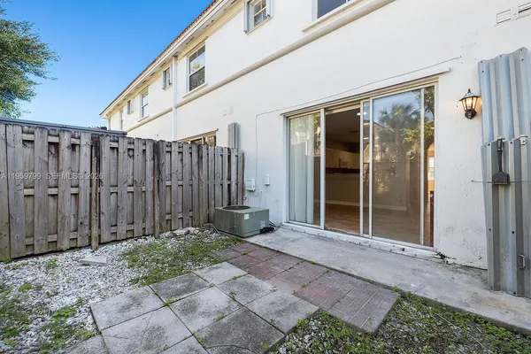 a view of a house with backyard and wooden fence