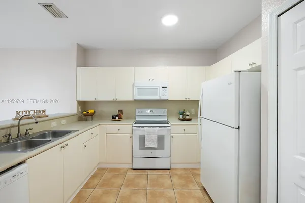 a kitchen with white cabinets and white appliances