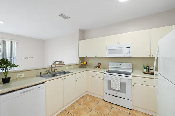 a kitchen with a sink dishwasher and white cabinets