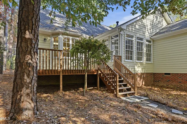 a view of a house with a yard and large tree
