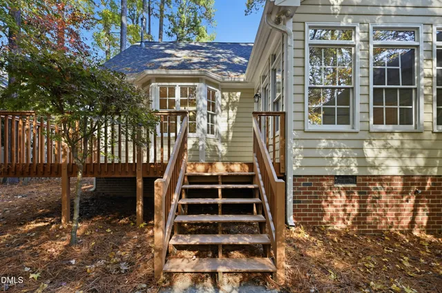 a view of a patio with table and chairs with wooden floor and fence