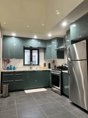 a large kitchen with stainless steel appliances granite countertop a sink and a stove top oven with wooden floor