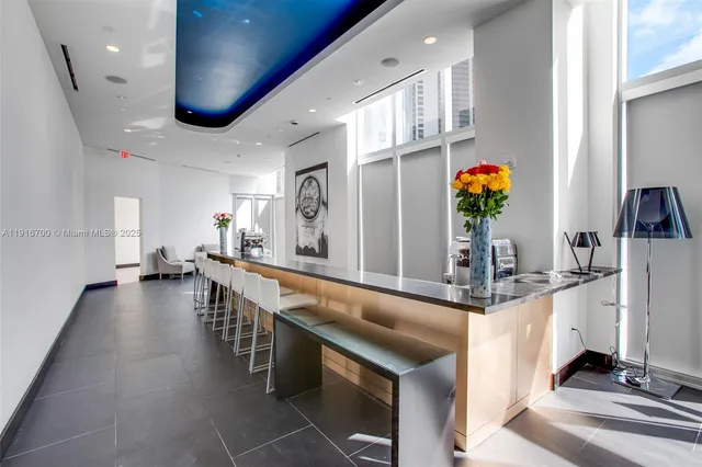 a dining hall with stainless steel appliances granite countertop a sink and a refrigerator