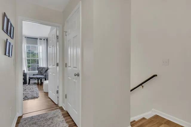 a view of a hallway with a livingroom and a dinning room with furniture