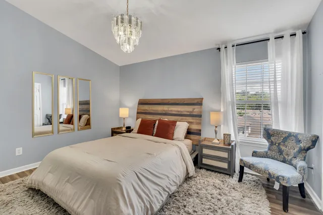 a bedroom with a large bed and a chandelier