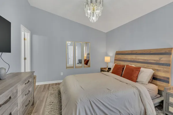 a bedroom with a large bed and a chandelier