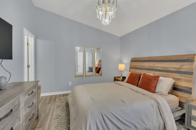 a bedroom with a large bed and a chandelier