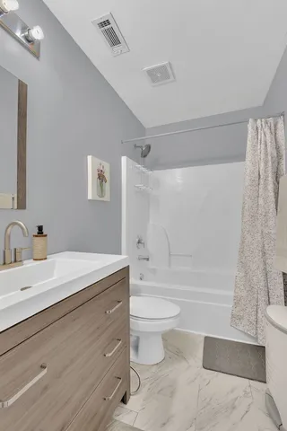 a bathroom with a granite countertop sink toilet and shower