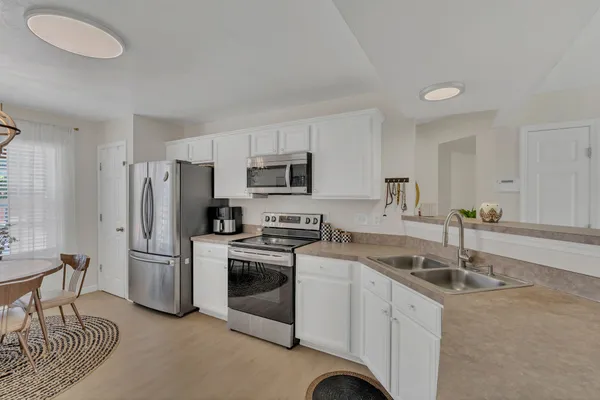 a kitchen that has a sink cabinets stainless steel appliances and a counter top space