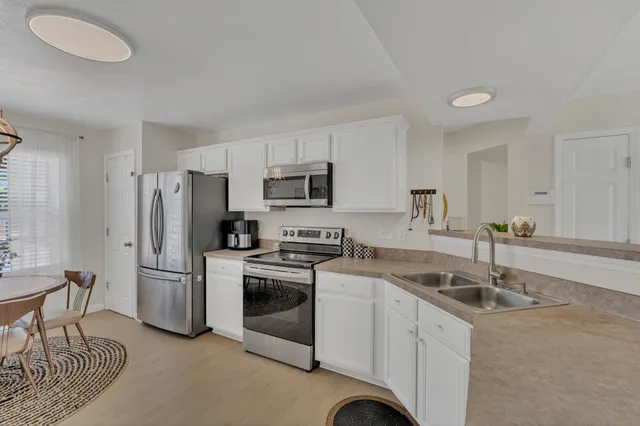 a kitchen that has a sink cabinets stainless steel appliances and a counter top space