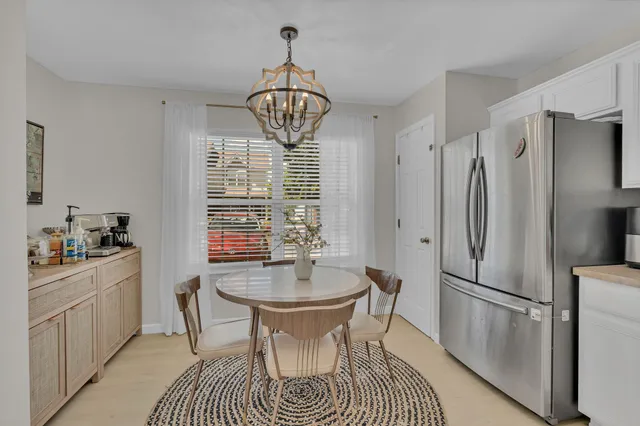 a kitchen with stainless steel appliances a dining table chairs and chandelier