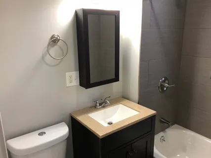 a bathroom with a toilet sink vanity and mirror